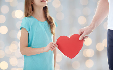 Image showing close up of girl and male hand holding red heart