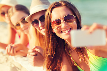 Image showing close up of smiling women with smartphone on beach