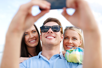 Image showing group of friends taking selfie with cell phone