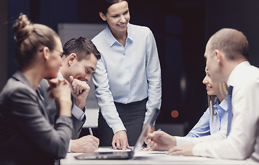 Image showing smiling female boss talking to business team