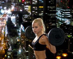 Image showing sporty woman exercising with barbell