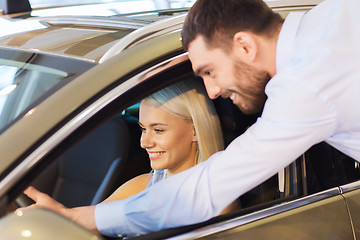 Image showing happy couple buying car in auto show or salon