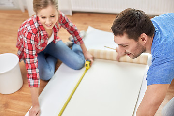 Image showing close up of couple measuring wallpaper