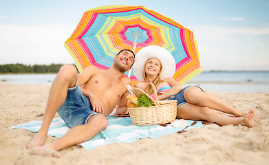 Image showing couple having picnic and sunbathing on beach