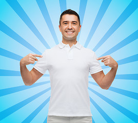 Image showing smiling man in t-shirt pointing fingers on himself