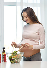 Image showing happy pregnant woman preparing food at home