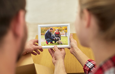Image showing close up of happy couple looking at family photo