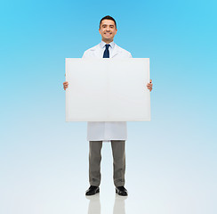 Image showing smiling male doctor holding white blank board