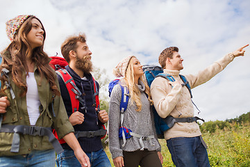 Image showing group of smiling friends with backpacks hiking