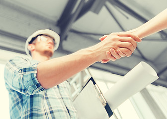 Image showing builder with blueprint shaking partner hand