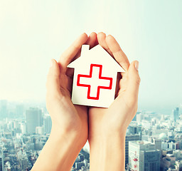 Image showing hands holding paper house with red cross