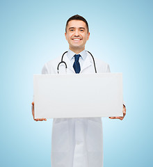 Image showing smiling male doctor holding white blank board