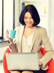 Image showing businesswoman at home with laptop and cup
