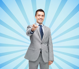 Image showing happy smiling businessman in suit pointing at you
