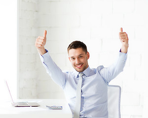 Image showing happy businessman showing thumbs up in office