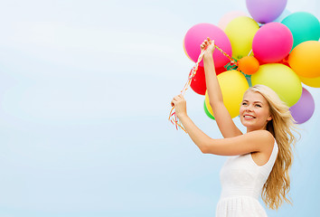 Image showing smiling woman with colorful balloons outside