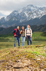 Image showing group of smiling friends with backpacks hiking