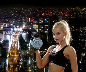 Image showing young sporty woman with heavy steel dumbbell