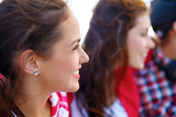 Image showing smiling teenage girl outdoors with friends