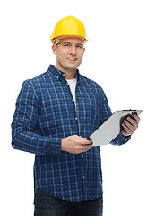 Image showing smiling male builder in helmet with clipboard