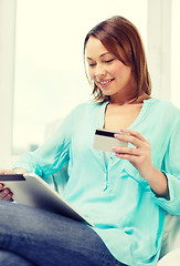 Image showing happy woman with tablet pc and credit card at home