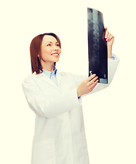 Image showing smiling female doctor looking at x-ray