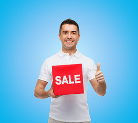 Image showing smiling man with red sale sigh showing thumbs up