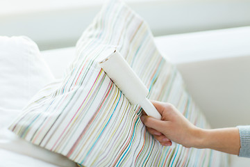 Image showing close up of woman hand with sticky roller cleaning