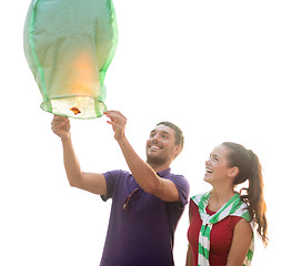 Image showing happy couple with chinese sky lantern on beach