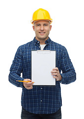 Image showing smiling male builder in helmet with clipboard