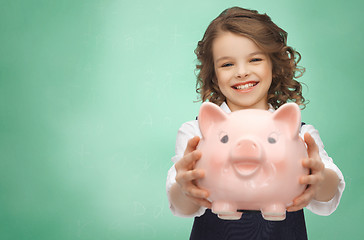 Image showing happy girl holding piggy bank 