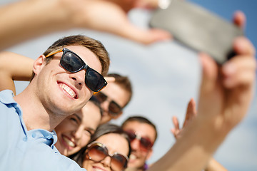 Image showing group of friends taking selfie with cell phone