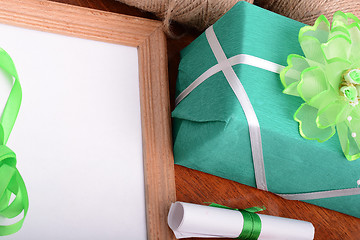 Image showing green gift box and wooden board, holiday concept