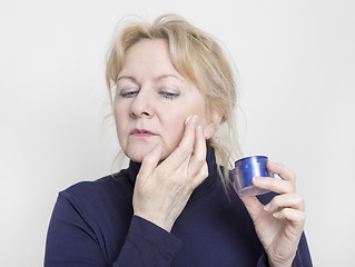 Image showing elderly woman with face cream