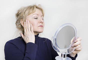 Image showing older woman looking in mirror