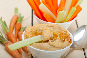 Image showing fresh hummus dip with raw carrot and celery 