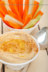 Image showing fresh hummus dip with raw carrot and celery 