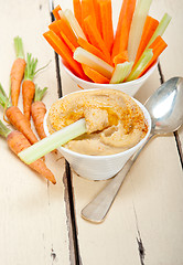 Image showing fresh hummus dip with raw carrot and celery 