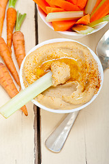 Image showing fresh hummus dip with raw carrot and celery 