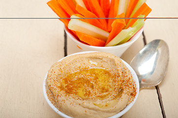 Image showing fresh hummus dip with raw carrot and celery 