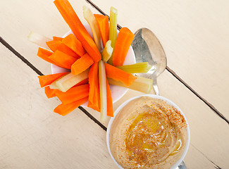 Image showing fresh hummus dip with raw carrot and celery 