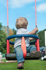 Image showing Cute baby boy watching back on swing