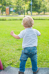 Image showing Baby kid walking on the green grass