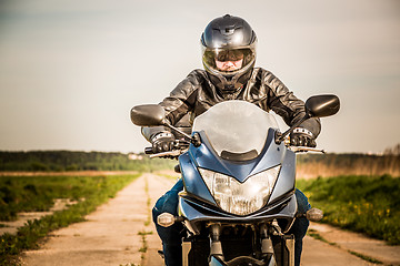 Image showing Biker racing on the road