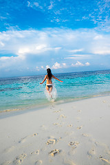 Image showing Girl walking along a tropical beach in the Maldives.