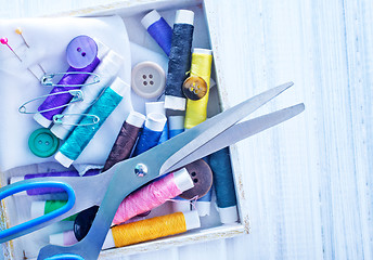 Image showing Scissors, bobbins with thread and needles