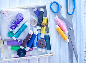 Image showing Scissors, bobbins with thread and needles