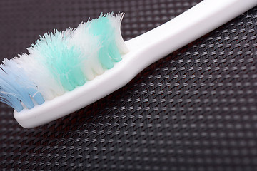 Image showing close - up old toothbrush on black material