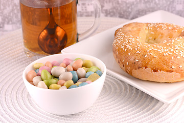 Image showing A cup of tea with a cake and candies