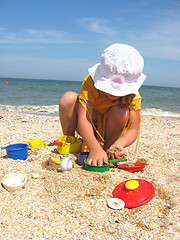 Image showing The little girl plays at the sea